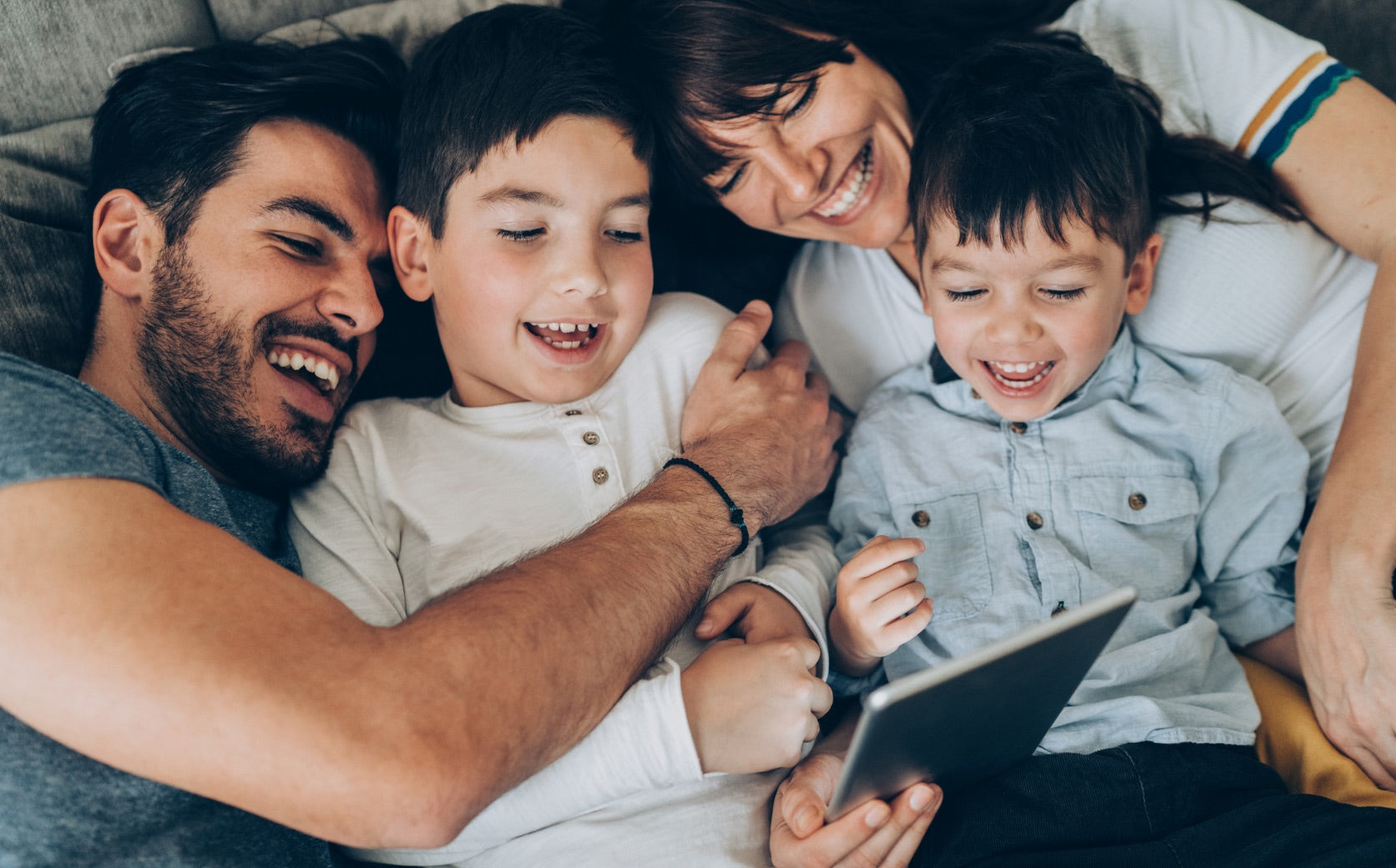 Familie schaut gemeinsam auf ein Tablet